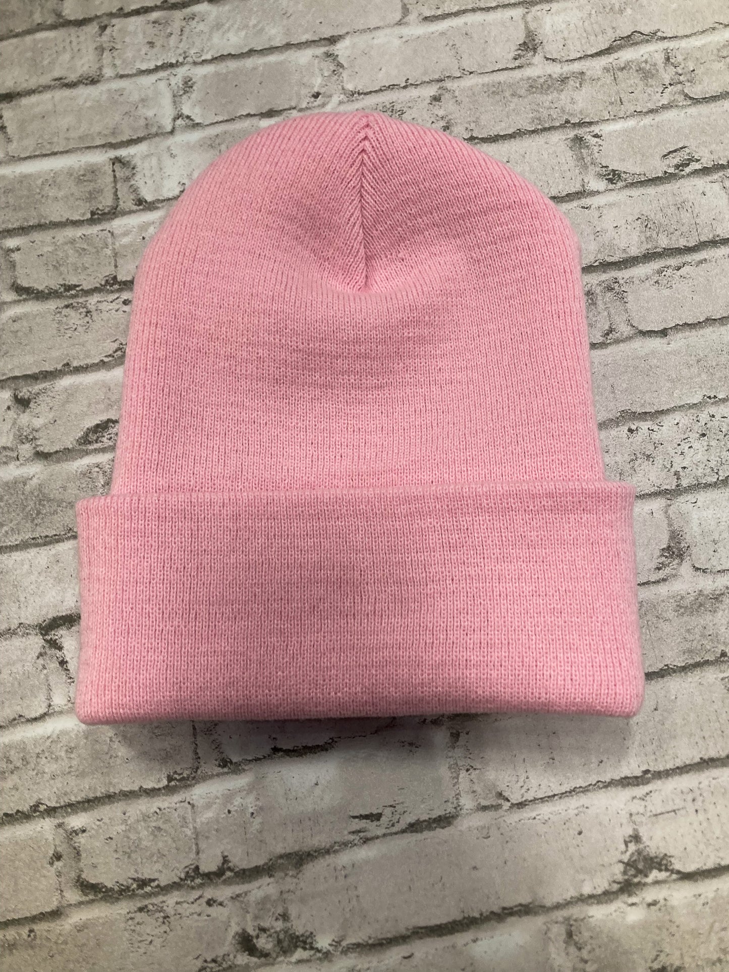 Back of product image of a streetwear beanie in pink, made from soft knit fabric.