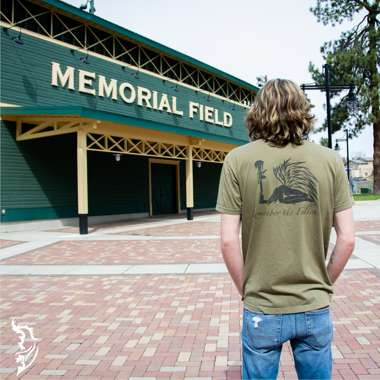 Back view of a men's tee featuring a hand-drawn angel kneeling with wings extended, before a soldier’s boot, rifle, helmet, and dog tags in tribute to fallen soldiers.