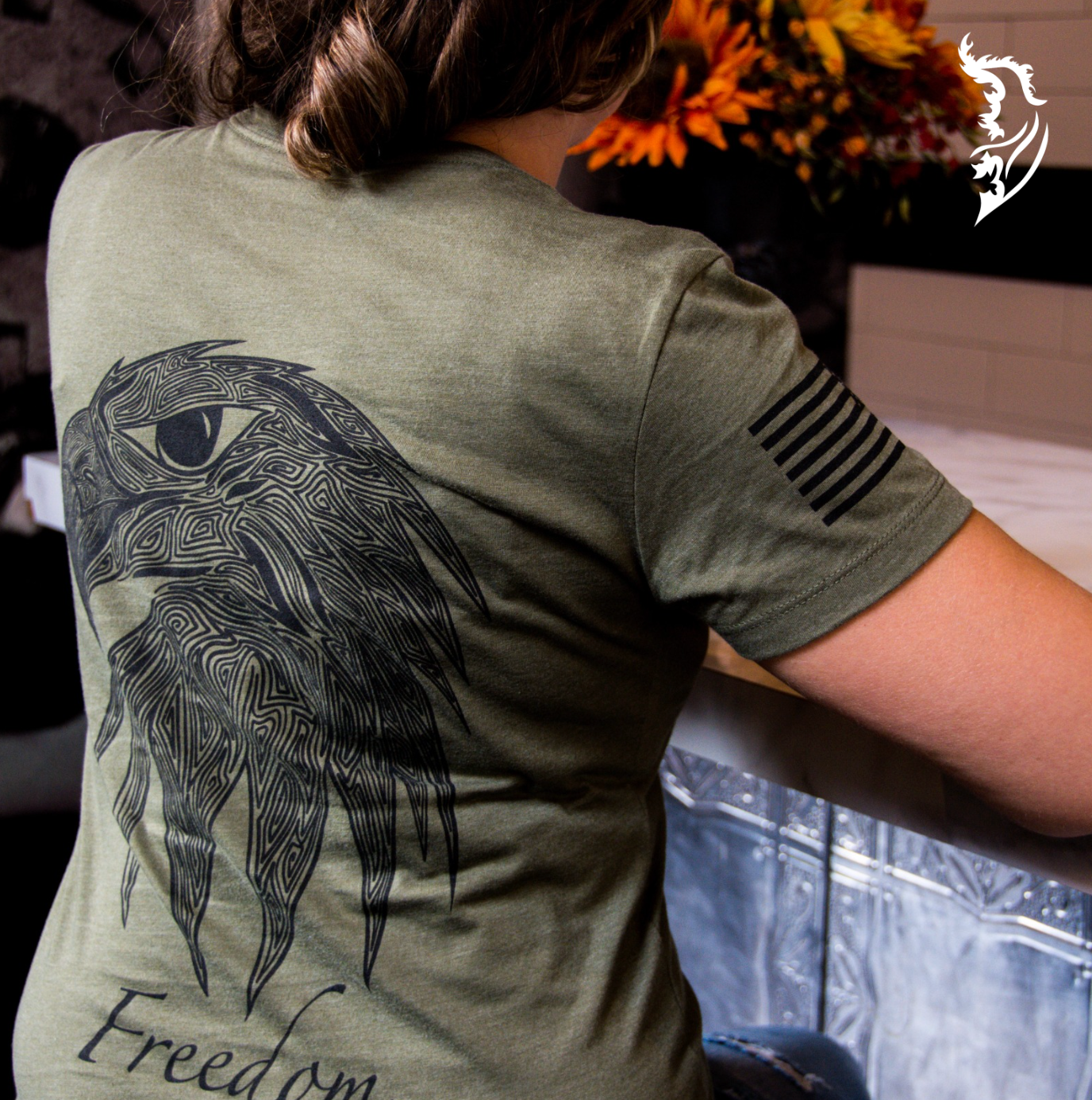 Detailed back print of a military green tee showcasing an eagle head with artistic linework and the word 'Freedom' beneath it.