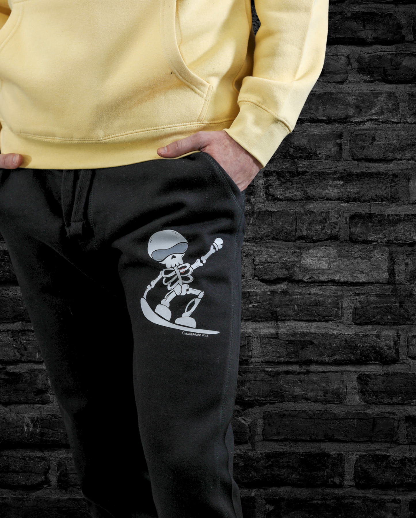 Model wearing ultra-soft fleece Skeleton Snowboarder joggers, featuring a bold hand-drawn design, styled for winter comfort and snowboarding lifestyle