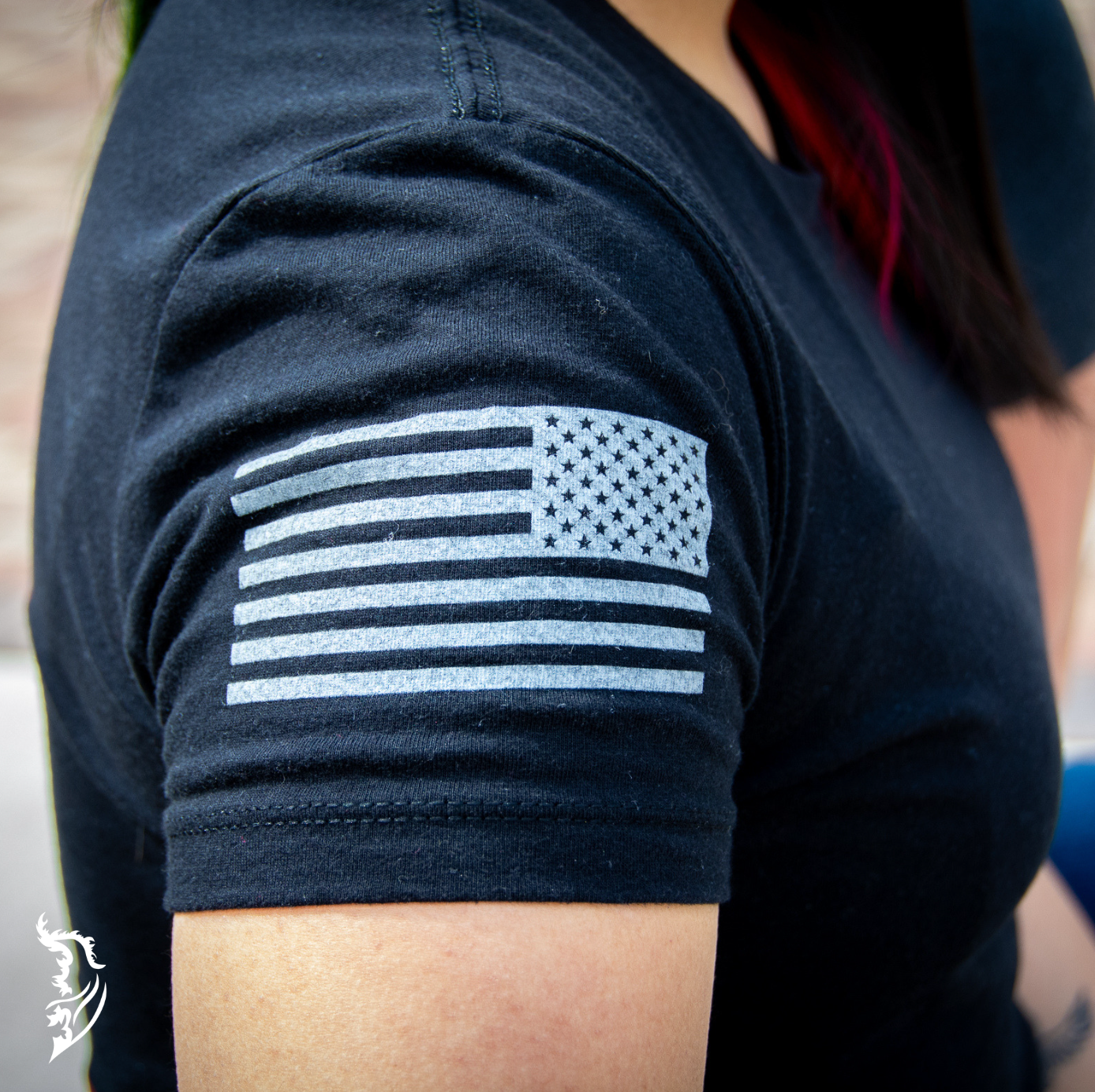 Side view of a black ladies tee featuring a Spartan helmet with American flag details on the back and subtle brand logo on the front chest.
