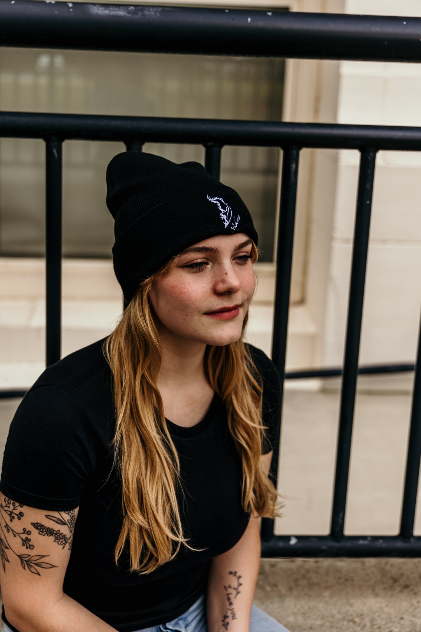 Model wearing a streetwear beanie in classic black, made from soft knit fabric.