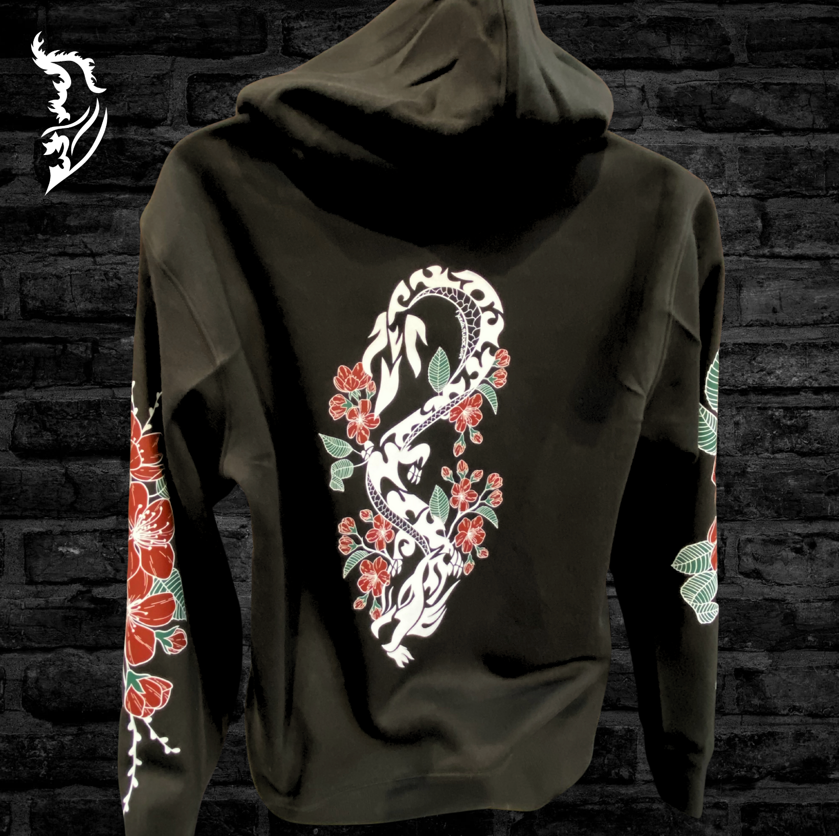 Black hand-drawn hoodie featuring cherry blossoms down each sleeve, a dragon intertwined with blossoms on the back, and a white angel wing logo on the left chest, symbolizing beauty, power, and the fleeting nature of life.