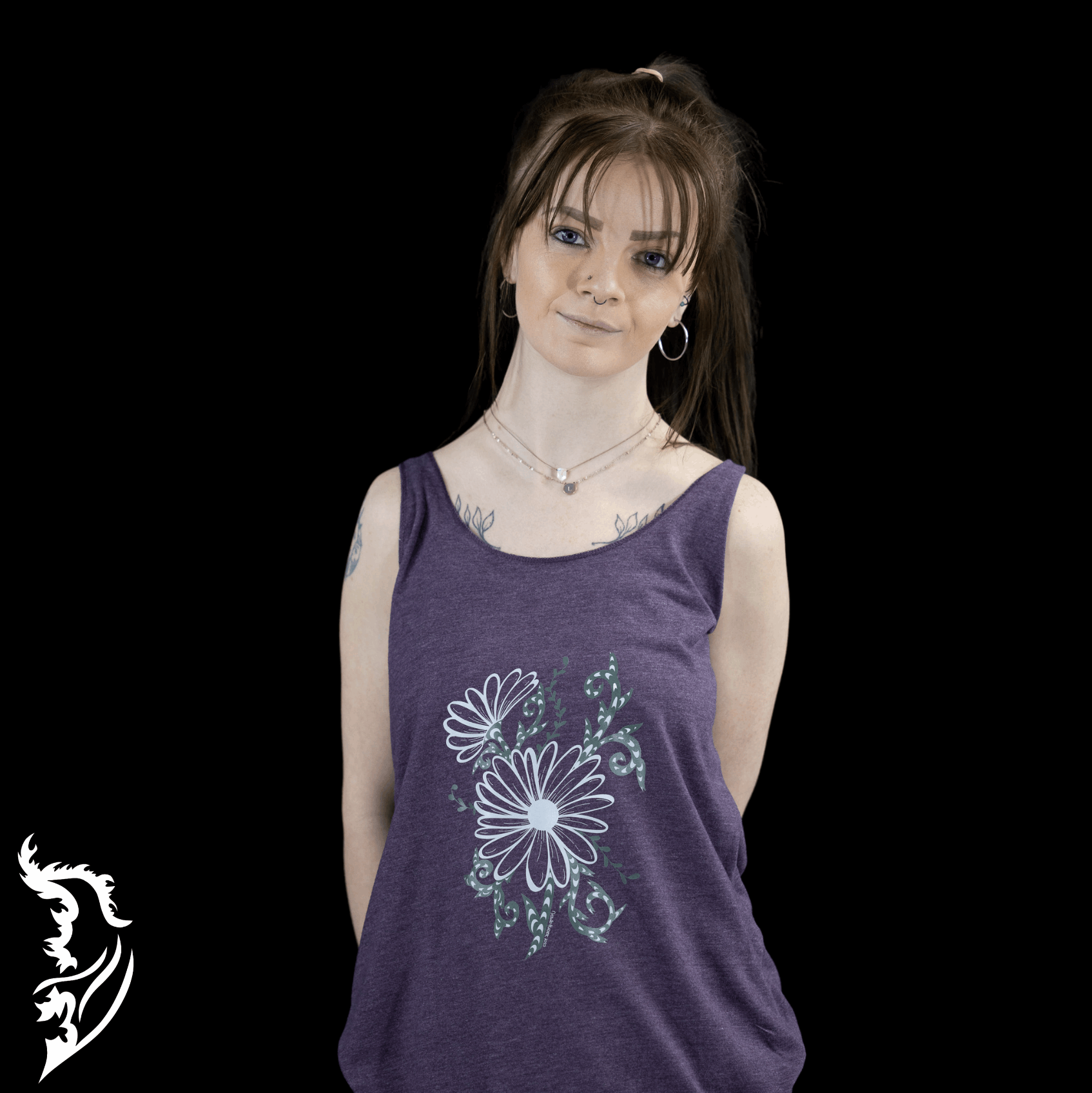 Woman wearing a purple tank top featuring a hand-drawn daisy  design with green vine accents by Street Style by Nickola, standing against a dark backdrop.