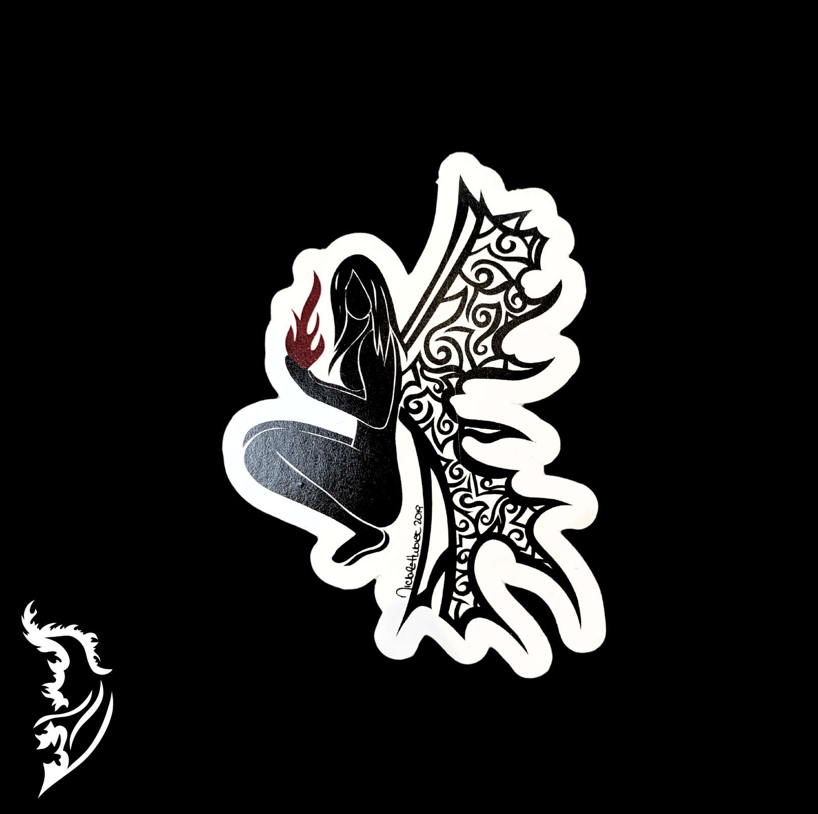 Black-and-white fairy silhouette vinyl sticker with intricate patterned wings and a small red flame detail