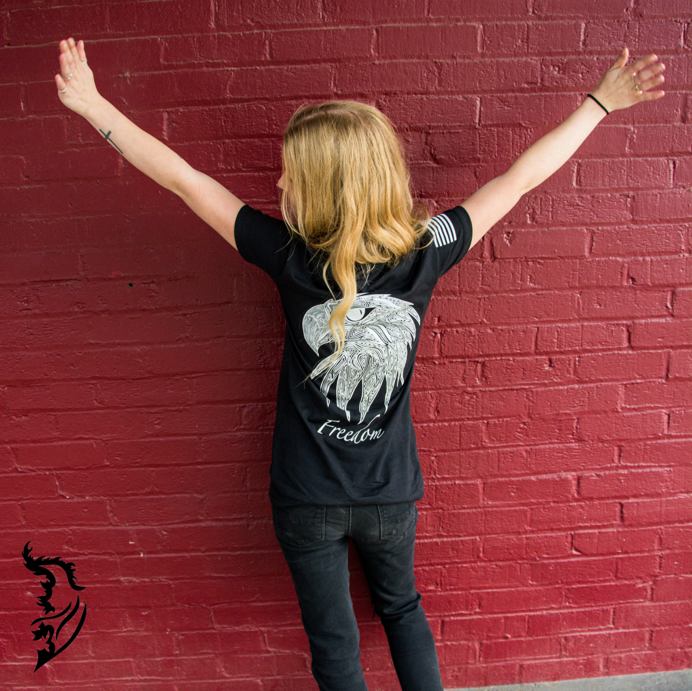 Black tee back print featuring an eagle head with intricate linework and 'Freedom' text, blending art and strength.