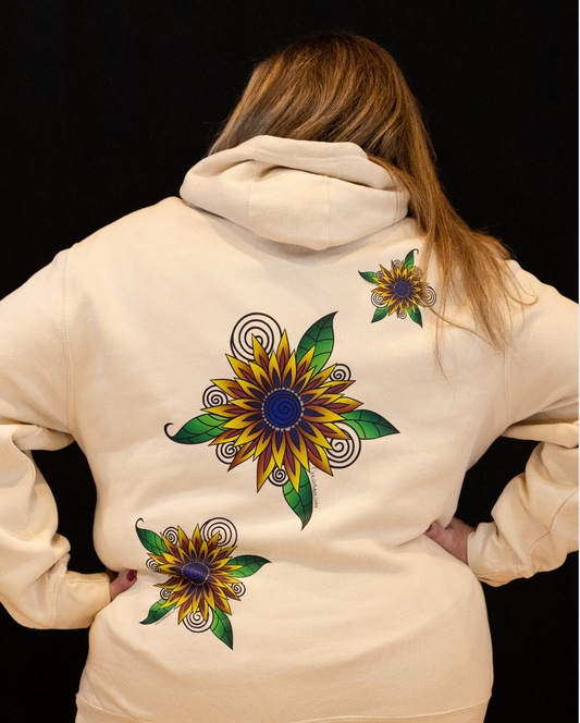 Back view of a woman wearing a Sandstone Street Style by Nickola hoodie featuring colorful sunflower hand-drawn artwork with swirling details and green leaves printed across the back.