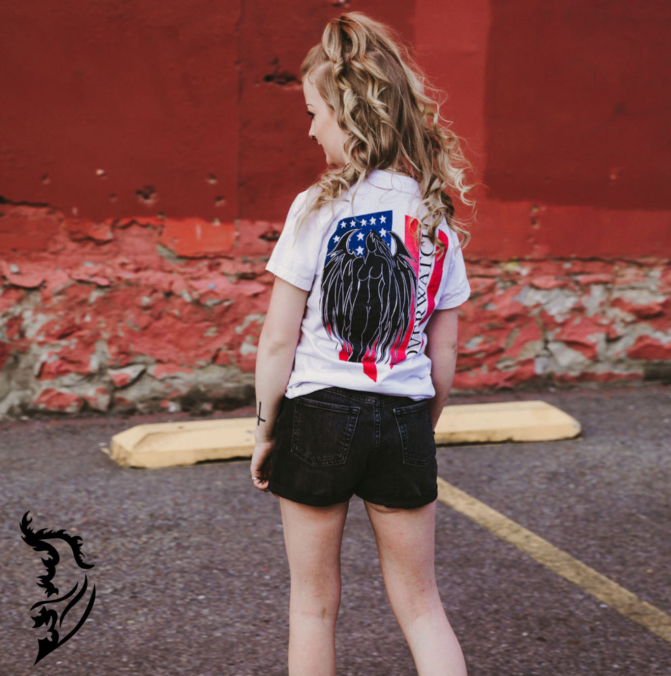 Model wearing Overwatch T-Shirt in parking lot. Showcasing Hand-drawn American Flag with Angel and Overwatch written down Flag