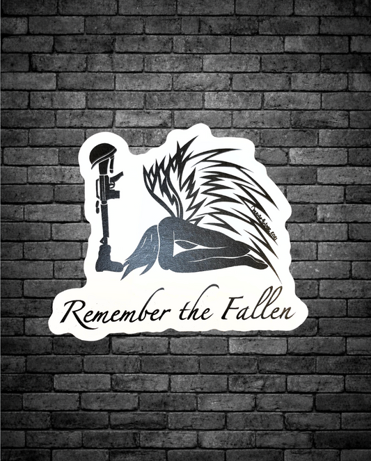  The design features a kneeling angel with detailed wings beside a rifle topped with a helmet, with the words “Remember the Fallen” written beneath. 