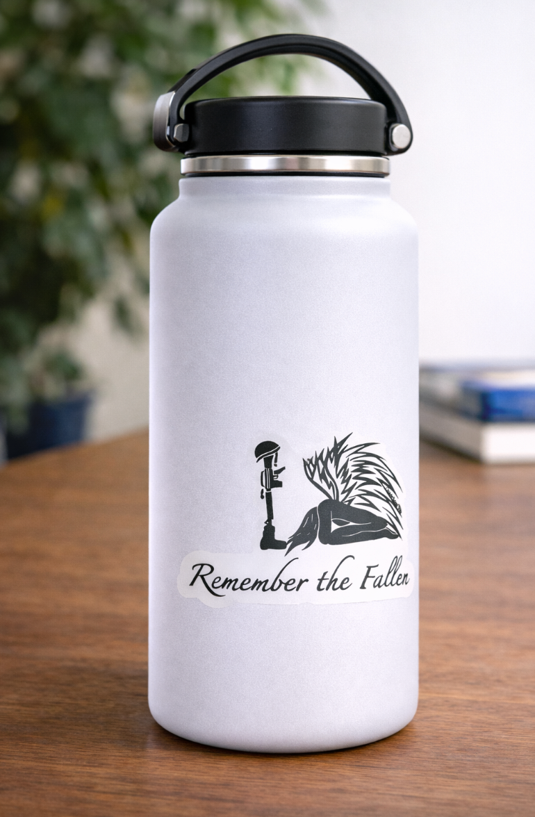 The design features a kneeling angel with detailed wings beside a rifle topped with a helmet, with the words “Remember the Fallen” written beneath. 