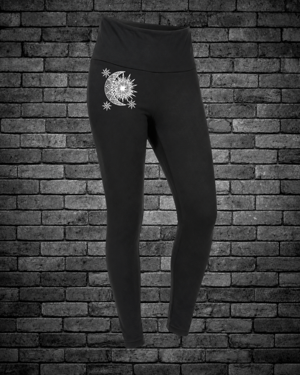 Black leggings with a hand-drawn Sun & Moon design on front of leggings  on a brick wall background