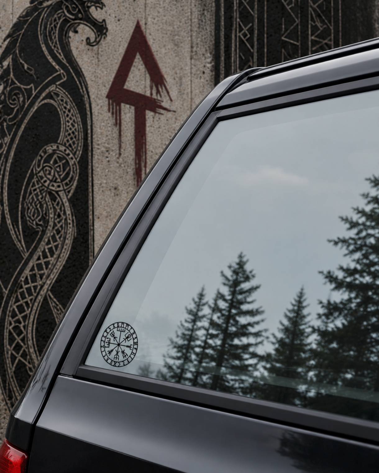 Car window with a Viking symbol decal, featuring a dragon and Runes design in the background.