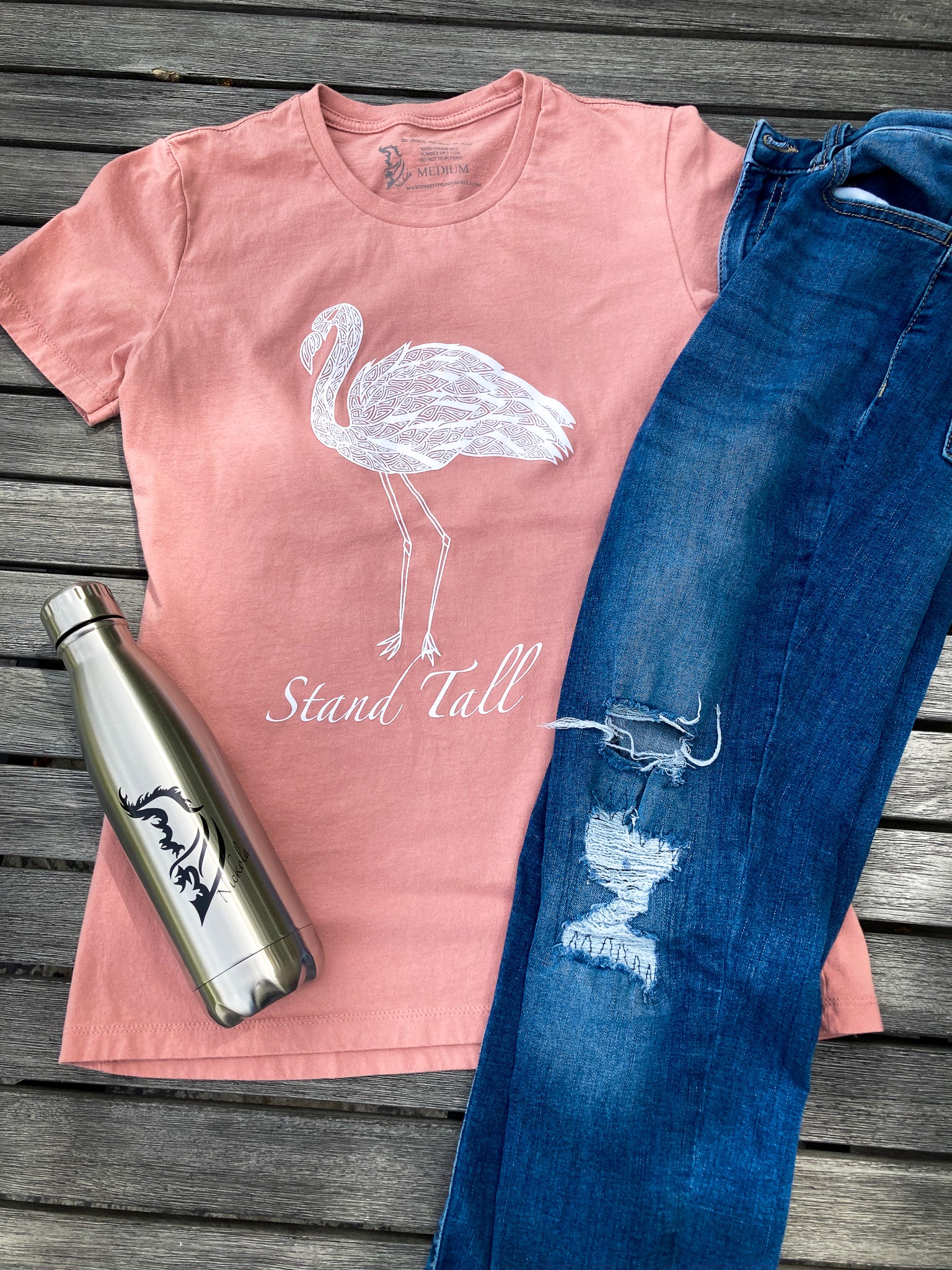 Hand-drawn Lined Flamingo with Stand Tall written below in white  on dessert pink shirt